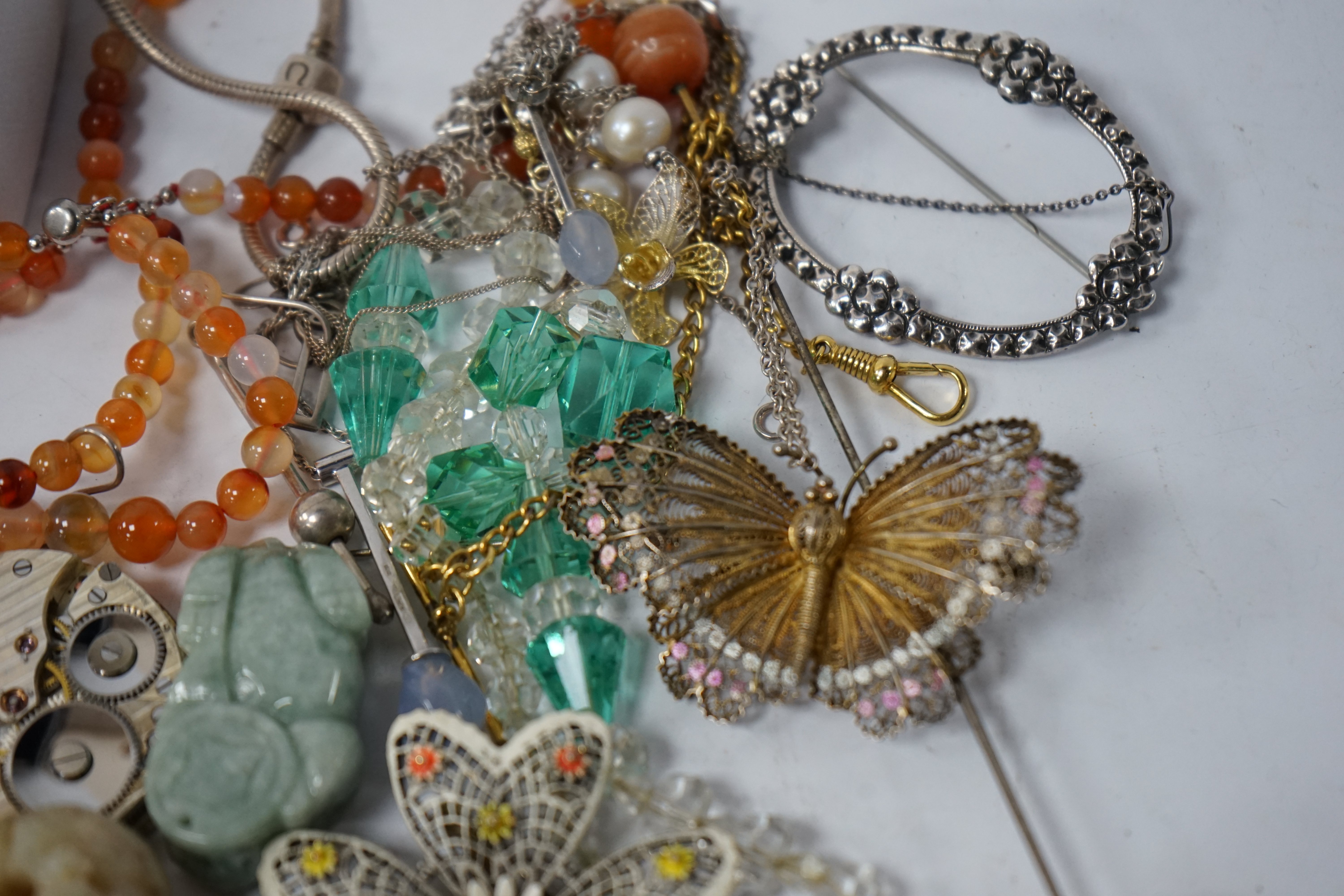 A small quantity of assorted jewellery and other items including a filigree butterfly brooch, a 925 and labradorite ring, an agate bead necklace, pocket watch movements, etc. Condition - poor to fair